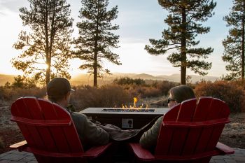 Adirondack chairs and fire pit facing beautiful scenery