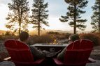 Adirondack chairs and fire pit facing beautiful scenery