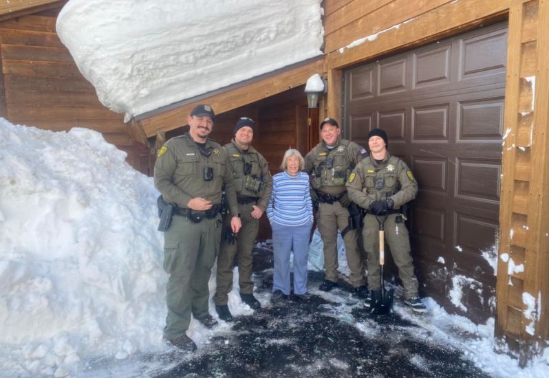 Washoe County Police Officers with an older woman on her snow shoveled driveway